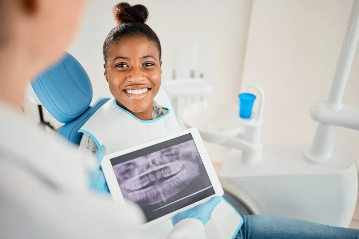 Patient viewing dental x-ray on tablet during wisdom teeth consultation at Studio One Dental