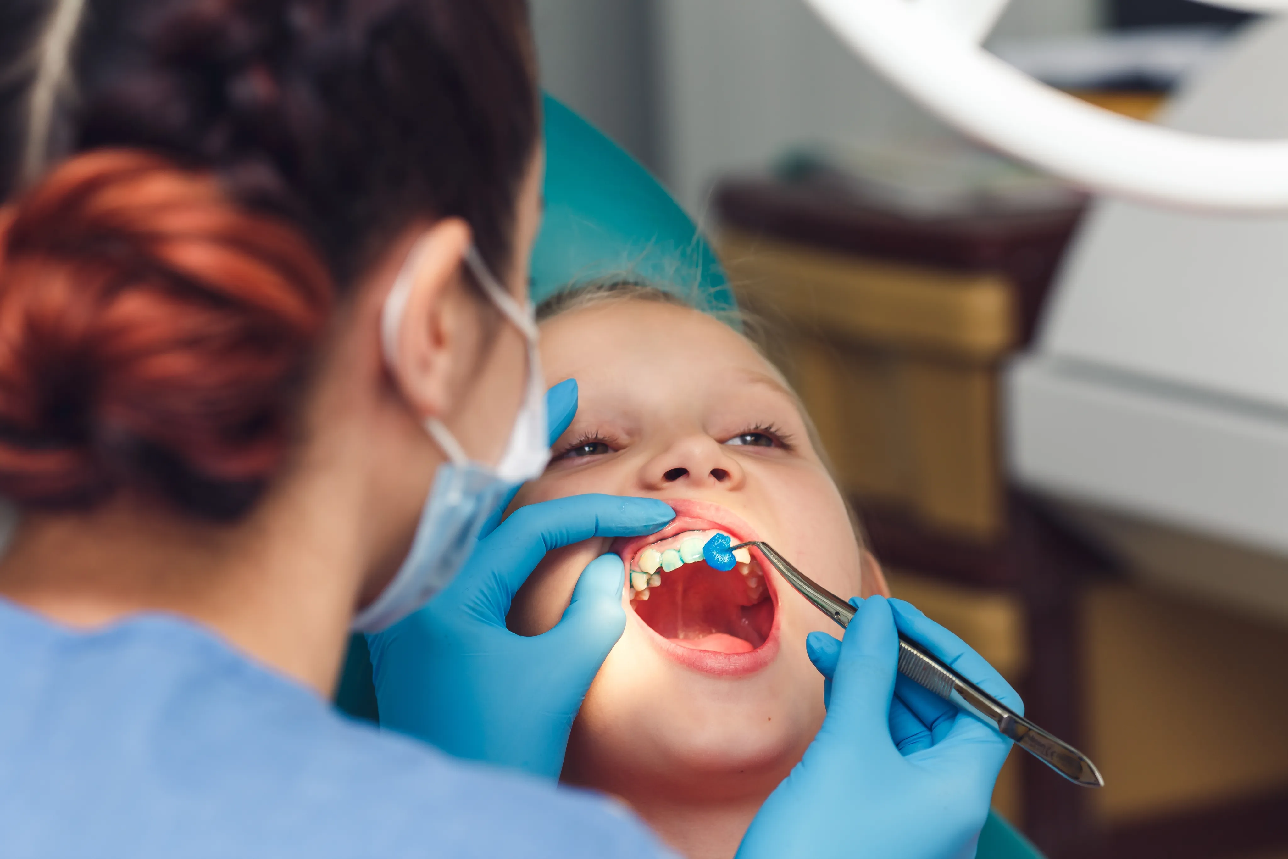 Child receiving professional fluoride treatment at Studio One Dental